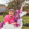 A man in a pink Twilight t-shirt with a cardboard unicorn