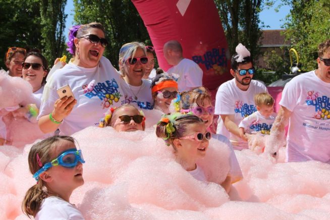 A family enjoying a bubble station at a family fun run Bubble Rush 