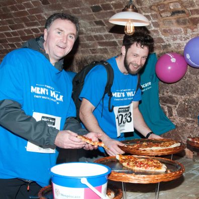 Men's Walk participants in Hospiscare t-shirts enjoy a pizza en route